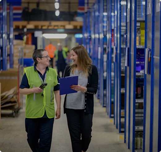 2 women talking in a warehouse